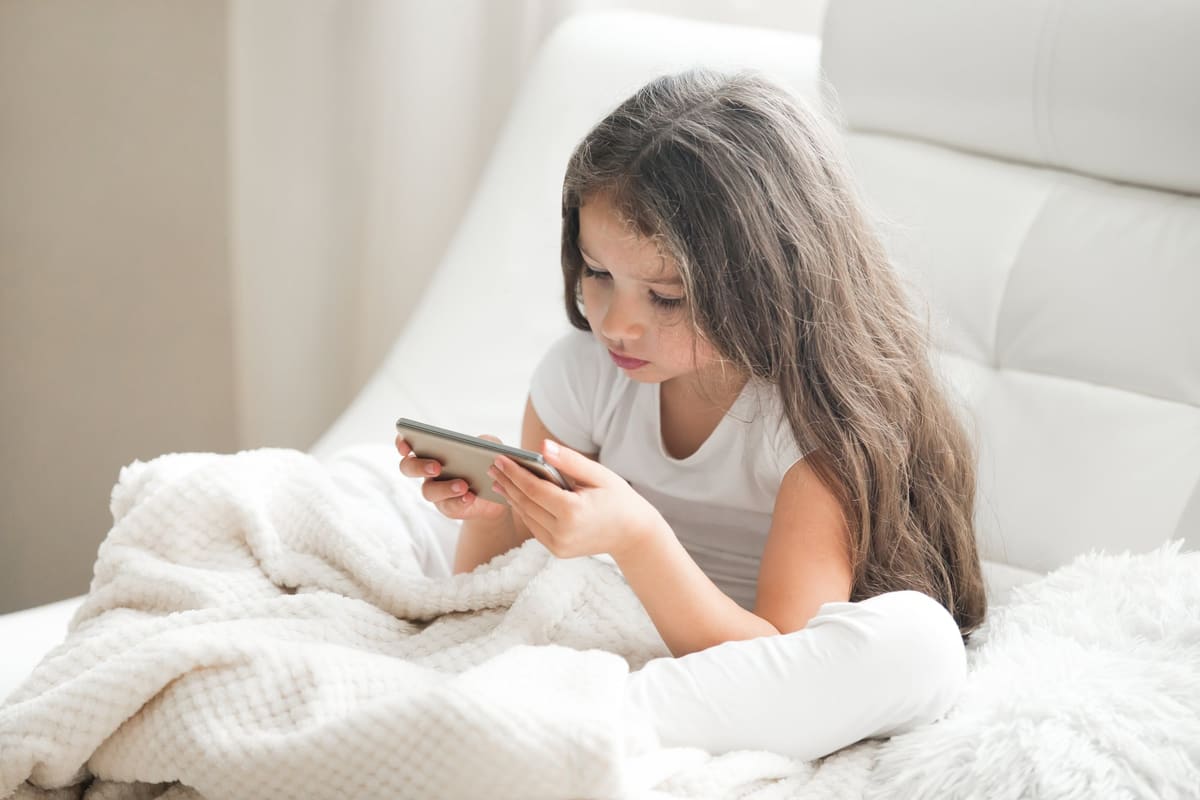 A young girl playing games on a tablet at home