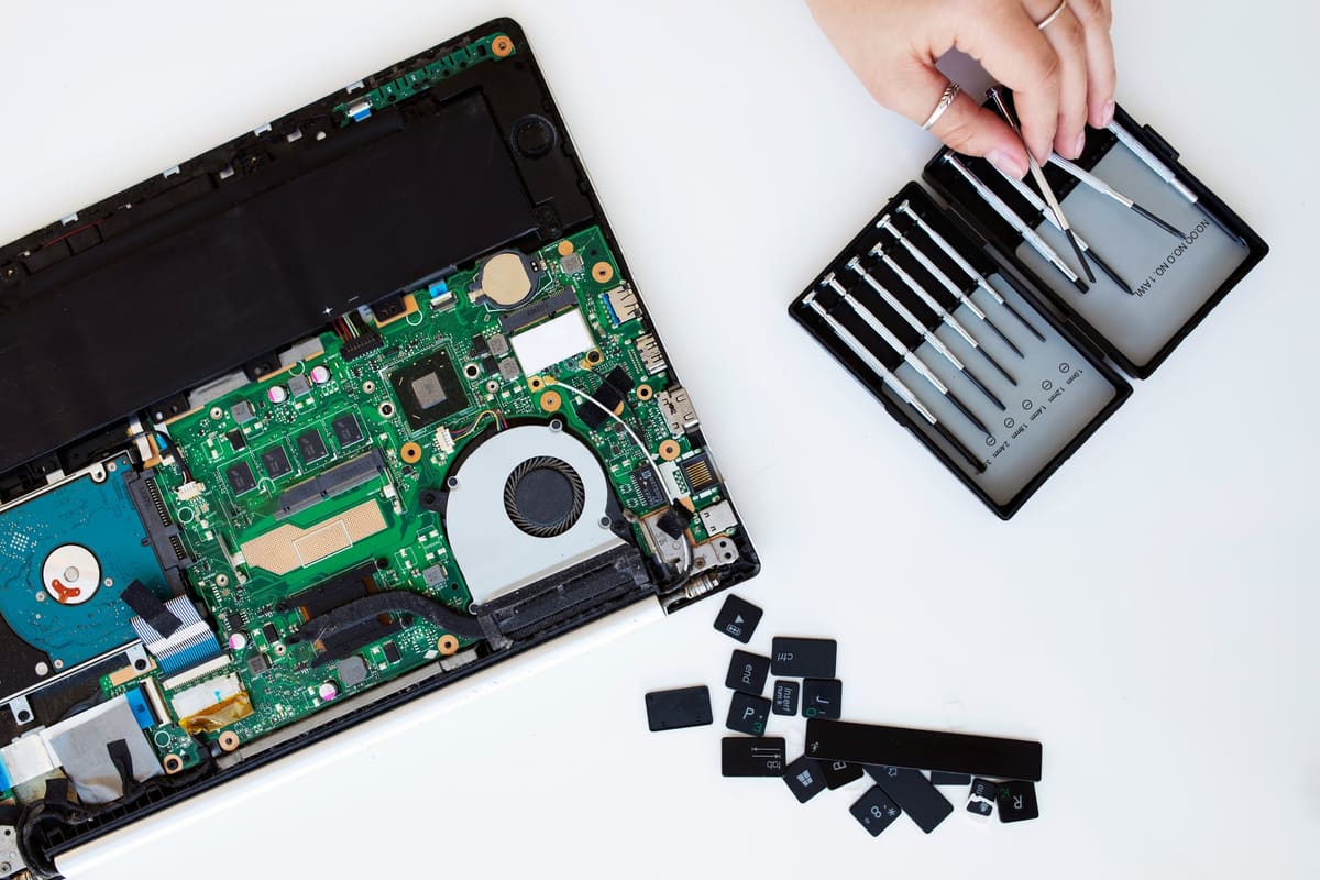 A young woman cleaning her laptop keyboard