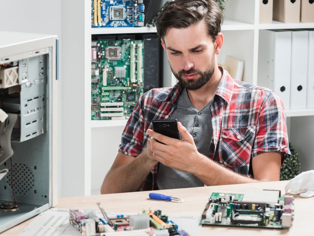 A technician on the phone in a repair workshop