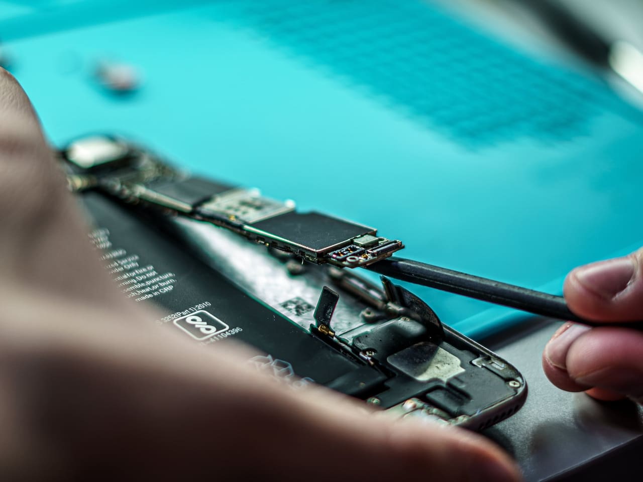 A technician repairing a mobile phone in a workshop